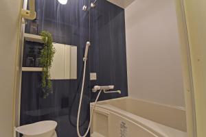 a bathroom with a shower with a tub and a toilet at ID STAY Haneda in Tokyo