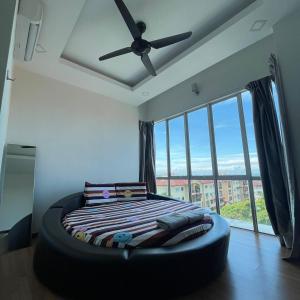 a bedroom with a large bed with a ceiling fan at Countryside Condo @One Residence Sekinchan in Sekincan