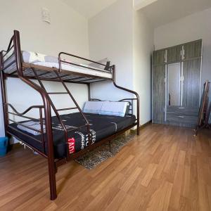 a room with two bunk beds and a wooden floor at Countryside Condo @One Residence Sekinchan in Sekincan