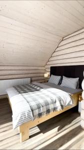 イズキにあるЧотири сезониの木製の天井の客室のベッド1台分です。