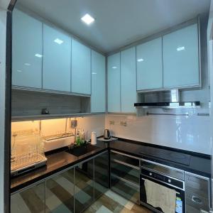 a large kitchen with blue cabinets and a sink at Countryside Penthouse @ One Residence Sekinchan in Sekincan