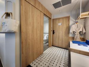 a bathroom with a wooden door and a sink at Kram Pattaya in Pattaya North