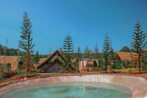 a house with a swimming pool and trees in the background at Yellowstone Camps Resort Khao Yai in Pak Chong
