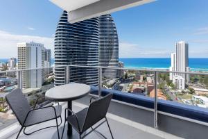a balcony with a table and chairs and the ocean at Meriton Suites Broadbeach in Gold Coast
