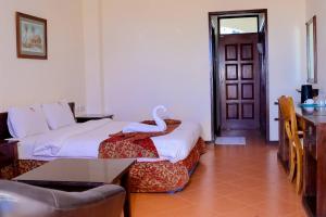 a hotel room with a bed with a swan on it at Sunrise Resort Apartments and SPA - Nyali, Mombasa, Kenya in Mombasa