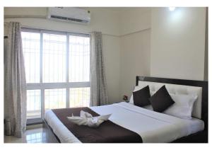 a bedroom with a large bed with a large window at Passion Homes in Mumbai