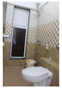 a bathroom with a toilet and a shower with a window at Passion Homes in Mumbai