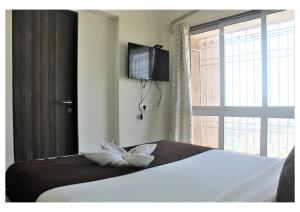 a bedroom with a bed with a television and a window at Passion Homes in Mumbai