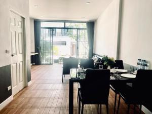 a dining room with a table and chairs and a door at PP GRAND KAMALA HOTEL-SHA Extra Plus in Kamala Beach