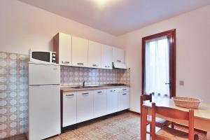 リニャーノ・サッビアドーロにあるVilla Celliniのキッチン(白いキャビネット、テーブル、電子レンジ付)