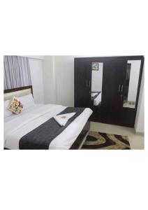 ein Hotelzimmer mit einem Bett und einem Spiegel in der Unterkunft Artist Alley Apartments in Mumbai