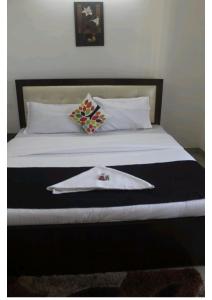 a bed with a white blanket and a napkin on it at Artist Alley Apartments in Mumbai