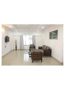 a living room with a couch and a table at Artist Alley Apartments in Mumbai