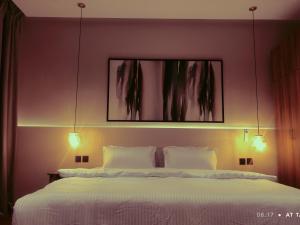 a bedroom with a bed with two lights above it at مساكن خاصة بتصميم فندقي ووصول ذاتي in Taif