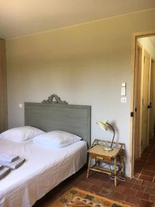 a bedroom with two beds and a table with a lamp at Villa neuve et moderne avec piscine à Grimaud in Grimaud