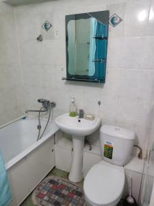 uma casa de banho com um WC, um lavatório e um espelho. em X,ata 2 em Almaty