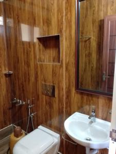 a bathroom with a sink and a toilet and a mirror at CHEENI HILL RESORTS in Kanthalloor