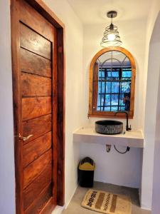 un bagno con una porta di legno e uno specchio di Cozy Cabin Casita Anahaw a Indang