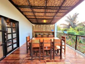 a dining room with a table and chairs on a balcony at Cozy Cabin Casita Anahaw in Indang