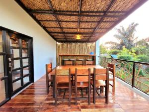 una sala da pranzo con tavolo e sedie su un balcone di Cozy Cabin Casita Anahaw a Indang Altre 21 foto