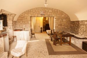 a living room with a table and a stone wall at Agriturismo La Commenda-Adults Only in Cascia