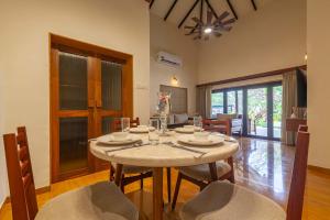een eetkamer met een tafel en stoelen bij StayVista's Lush Villa - Lake-View Haven with Rustic-Meets-Modern Interiors, Pool, Jacuzzi & Indoor activities in Wādhiware