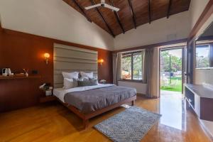 Llit o llits en una habitació de StayVista's Lush Villa - Lake-View Haven with Rustic-Meets-Modern Interiors, Pool, Jacuzzi & Indoor activities