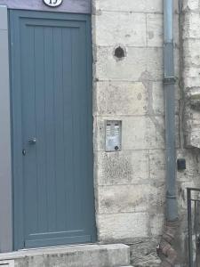 une porte bleue sur le côté d'un bâtiment en pierre dans l'établissement Maison DE LUR, à Périgueux