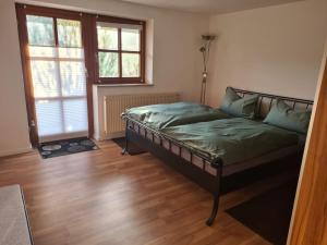 um quarto com uma cama com lençóis verdes e uma janela em Altmühltaler Ferienwohnung em Beilngries