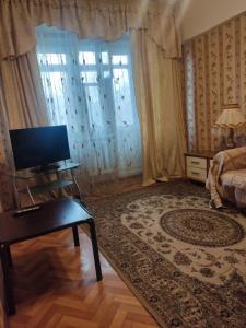 1 dormitorio con 1 cama y escritorio con TV en X.ata 3 en Almaty