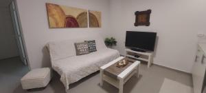 uma pequena sala de estar com uma cama e uma televisão em פינה קטנה בערבה em Beʼer Ora