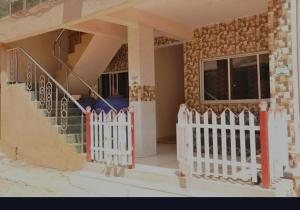 una casa con una valla blanca y una escalera en Sky Cottage Matheran en Matheran