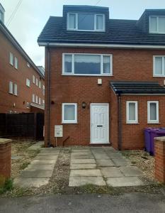 a brick house with a white door and a driveway at Entire House with 3 Rooms in Liverpool