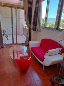 光復鄉的住宿－楓情休閒渡假莊園，客厅配有红色的沙发和玻璃桌