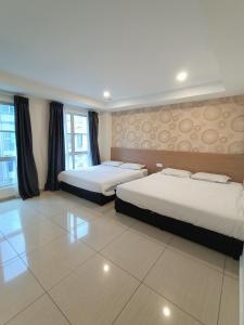 Cette chambre comprend 2 lits et 2 fenêtres. dans l'établissement DYAYA Hotel, à Malacca