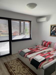 a bedroom with a bed and two windows at KTB Manastira Holiday Village in Oreshak