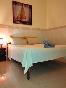 a bedroom with a large bed with a painting on the wall at Stay in Kampot in Kampot
