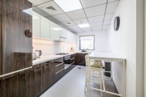 a kitchen with wooden cabinets and a white counter top at Unique Cosy &Spacious 2BR In Al Sufouh in Dubai