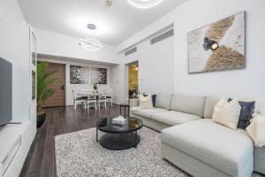 a living room with a couch and a table at Unique Cosy &Spacious 2BR In Al Sufouh in Dubai