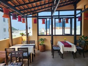 a restaurant with two tables and chairs and windows at 5 Elements Hotel in Quy Nhon