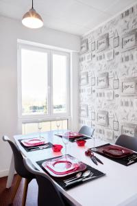 een eetkamer met een tafel en stoelen en een muur bij Perle de la somme - Parking - Gare d Amiens in Amiens