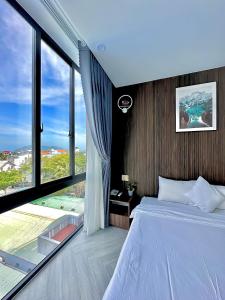 Tuấn Ninh Hotel II في كون داو: غرفة نوم بسرير ونافذة كبيرة