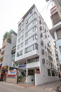 a large white building on a city street at 22Housing luxury Hotel & Residence 39 Linh Lang in Hanoi