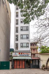 a tall white building with a store in front of it at 22housing Residence Suites 20 linh Lang in Hanoi