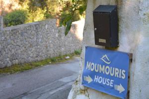 un cartello sul lato di un edificio con una casa di Moumouri's House a Gastouri