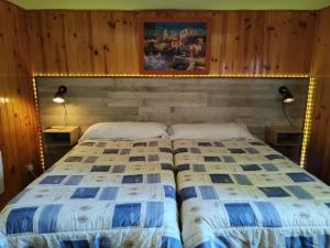 a bedroom with a bed and two night stands and two lamps at Casa LLANO43 Lago & Montaña in Las Rozas de Valdearroyo