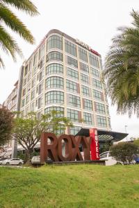 um grande edifício com um sinal rory em frente dele em Roxy Hotel & Apartments em Kuching