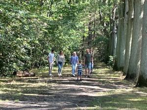 een familie die over een pad in het bos loopt bij de Swaenhoeve in Zoersel