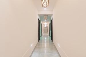 um corredor com paredes brancas e uma porta branca em FabHotel Silver Stone Inn em Lucknow