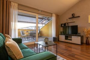 ein Wohnzimmer mit einem grünen Sofa und einem TV in der Unterkunft PENTHOUSE J&A in Vela Luka